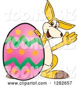 Vector Illustration of a Cartoon Kangaroo Mascot Waving by a Giant Easter Egg by Mascot Junction