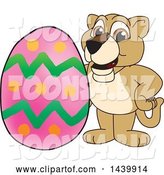 Vector Illustration of a Cartoon Lion Cub School Mascot with an Easter Egg by Toons4Biz