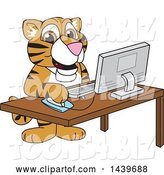 Vector Illustration of a Cartoon Tiger Cub Mascot Using a Computer by Mascot Junction