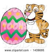 Vector Illustration of a Cartoon Tiger Cub Mascot with an Easter Egg by Mascot Junction